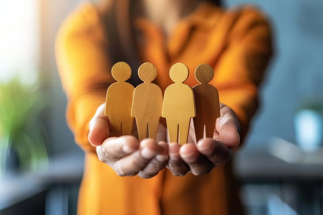 Hands-of-a-woman-with-4-cut-outs-in-the-shape-of-people-on-her-hands